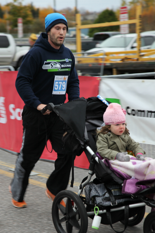Dad and Baby crossing finishline